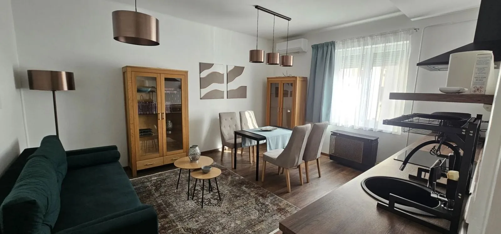 A nappali az étkezőasztallal, a vitrines szekrénnyel és a konyhapulttal
